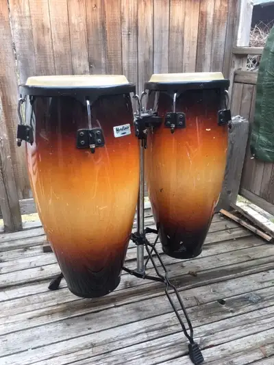 Pair of conga drums with stand made by Headlines, 12 inches across and 30 inches tall, stand. includ...