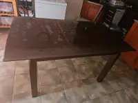 Table à manger en bois brun foncé.