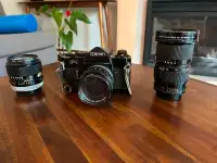 Canon F-1 film camera with three lenses