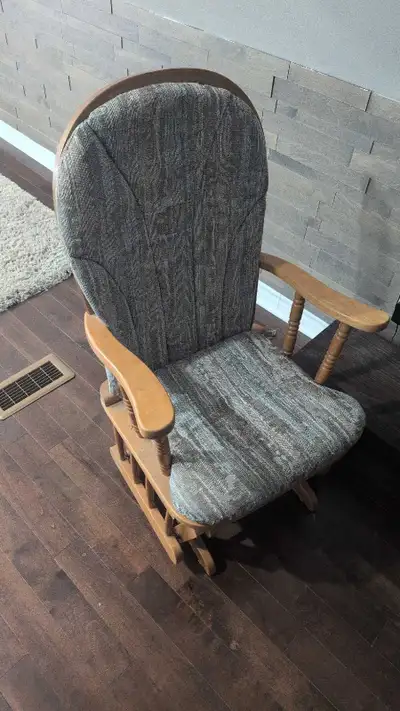 This is a used glider rocking chair, perfect for a nursery or living room. The chair features a stur...