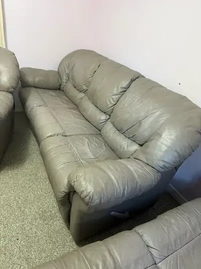 This comfy, used grey couch is perfect for a living room or den. It features plush cushions and a re...