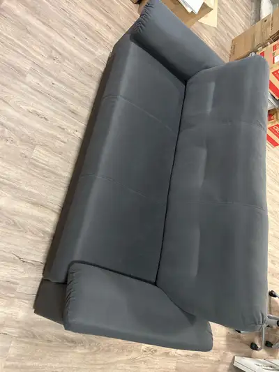 This is a grey IKEA sofa, perfect for adding a touch of modern comfort to your living space. It's in...