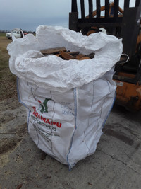 Spruce firewood rough cut dry slabs in large tote bags.
