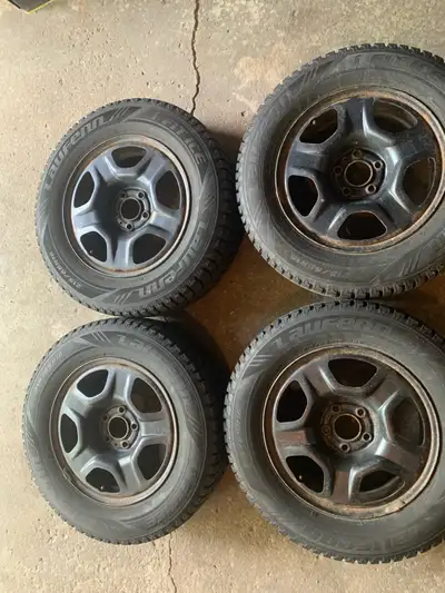 These are four used Laufenn I FIT ICE winter tires, size 215/65R16, mounted on 5 spoke steel rims. C...