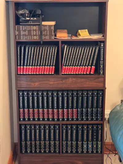GENTLY USED, TWO COMPLETE SETS OF 1990 ENCYCLOPEDIAS AND SHELVES, View more