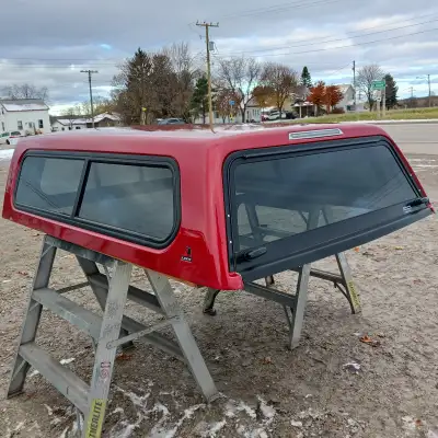 6'2", 2016-2023, Metallic Red, Front slider window, Rear locks work, Has some paint chips & marks al...