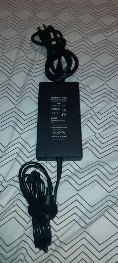 AC Adapter. This adapter is compatible with various devices with a 19.5V 6.15A requirement.