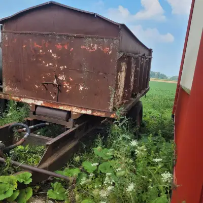 I'm selling a used dump trailer, perfect for hauling materials, though it shows signs of age and use...