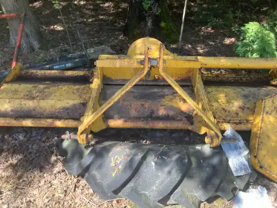 This farm equipment is a flail mower, ready to get back to work. The equipment shows signs of age an...