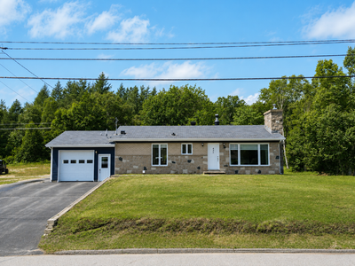 Propriété rénovée et soigneusement entretenue avec 2 garages, offrant une aire de vie lumineuse, une...