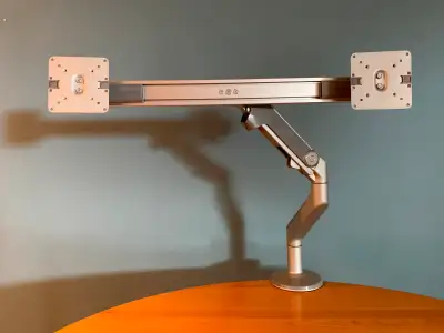 Dual Monitor Arm in perfect condition. Silver-plated color, sleek design. This dual monitor arm will...