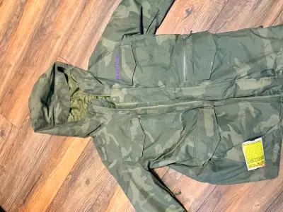 Stay warm and stylish on the slopes with this pre-owned Burton snowboard jacket in a classic camo pr...