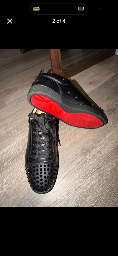 Elevate your footwear game with these used Christian Louboutin black leather sneakers, featuring a s...