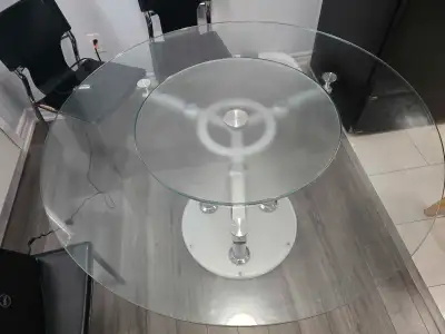 Selling glass dining table with a round tempered glass top and a chrome-finished metal base.