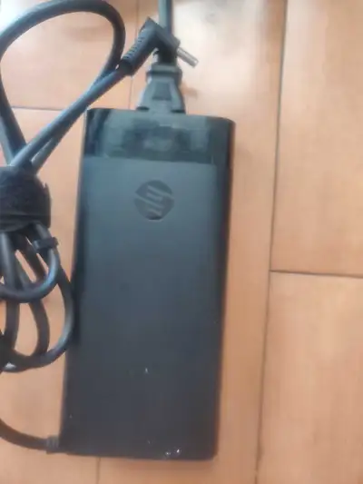 This is an HP 200W laptop charger, used but in good condition, providing reliable power for your HP...