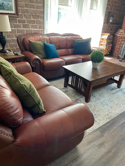 Four-piece leather living room set in excellent condition, featuring sofa, loveseat, chair, and otto...