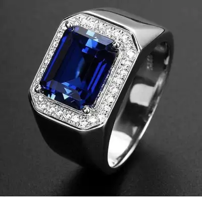 This is a used ring featuring a striking blue gemstone surrounded by smaller stones, set in a silver...