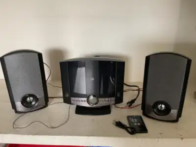 Home music system with 2 speakers, remote, clock, alarm. Sold as Is.