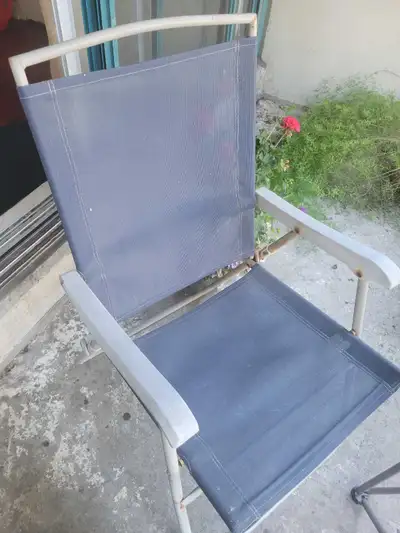 This folding outdoor patio chair is perfect for extra seating, featuring a durable grey fabric seat...