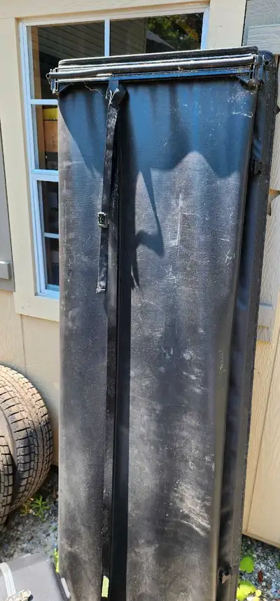 This is a folding tonneau cover for a 7-foot truck bed. It's in used condition, as you can see in th...