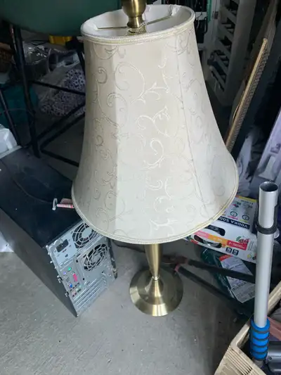 Add a touch of classic elegance to your home with this charming used table lamp, featuring a gold-to...