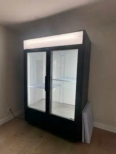 Two - Door Commercial display cooler. Glass doors with extra shelves. On wheels. Used for flower sto...