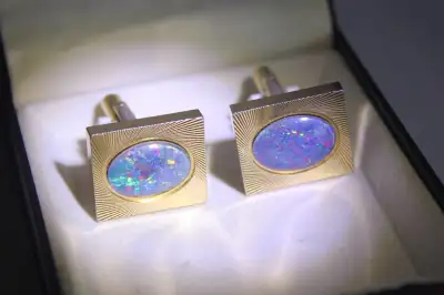 This is a beautiful pair of genuine fire opal cufflinks. The gems are mounted on rectangular gold pl...