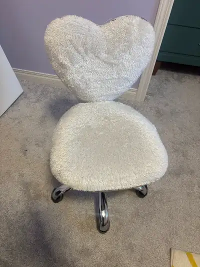 This is a comfy heart-shaped chair with a white fuzzy cover and chrome base. It's perfect for a kid'...