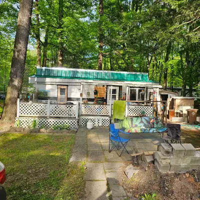 This cozy mobile home/camper is a fixer-upper that is located on a beautiful lot close to the creek....