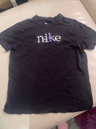 This is a like-new Nike kids shirt, size medium, featuring a stylish design. It's in excellent condi...