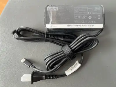 This is a brand new 65W Lenovo laptop charger, model number ADLX65VDC20,