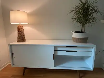 Spruce up your living space with this chic white sideboard! It features sleek sliding doors and two...