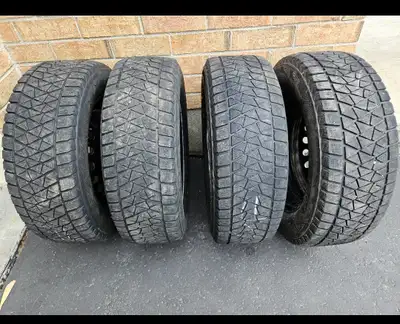 Set of four Bridgestone Blizzak DM-V2 winter tires mounted on 17-inch steel rims. Size: 235/65R17 Co...