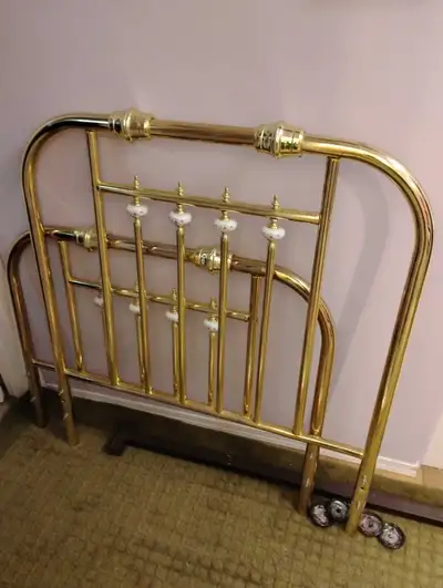 Brass twin bed frame with head and foot boards. Side rails hold a twin box spring. Painted ceramic k...