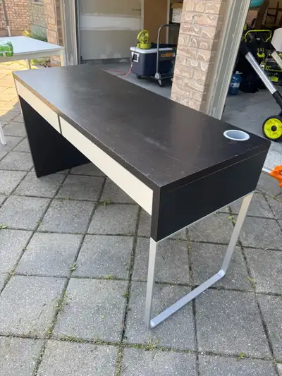 This is an IKEA study table with a sleek design and practical drawers, perfect for any home office o...