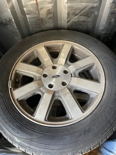 Four alloy rims and tires from 2009 Ford Taurus X. 5 x 114.3 mm (5 x 4.5") bolt pattern with 52 mm o...
