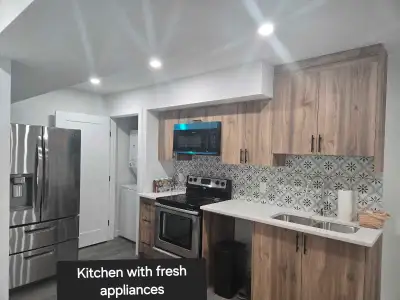 This basement for rent features fresh appliances, a bright washroom with a soaker tub, and a persona...