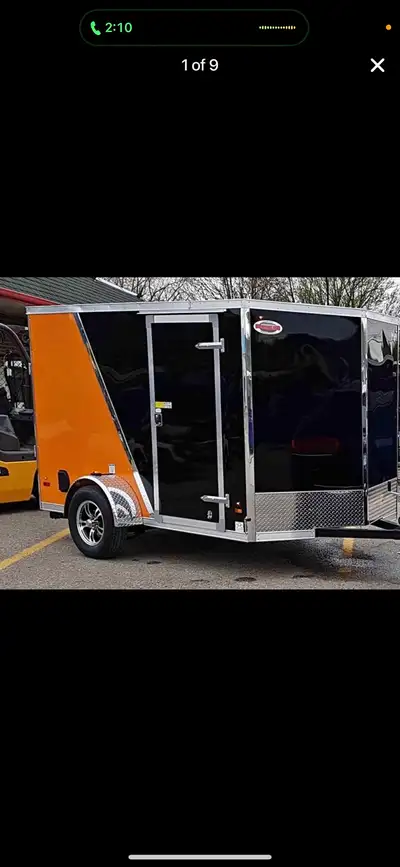 This pre-owned cargo trailer features a striking black and orange exterior finish and is in excellen...