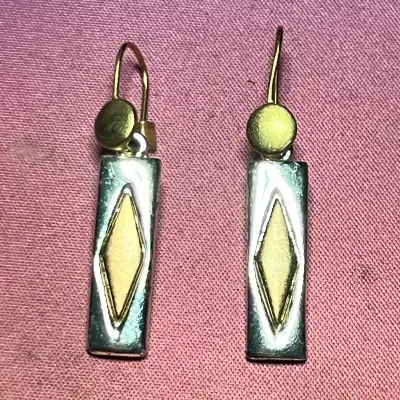 These elegant two-tone drop earrings feature a sophisticated rectangular design with a centered diam...