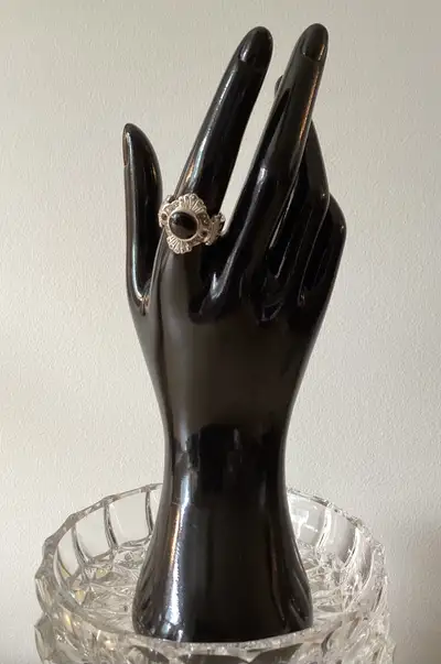 This gorgeous sterling silver ring has a large central black onyx stone, one smaller purple cubic zi...
