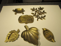 Assorted vintage brass ashtrays and decor pieces.