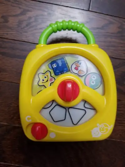 NEW- MUSIC PLAYING PHONE PLAYS MUSIC WHEN SHAPES ARE TURNED ON. PHONE DIAL WITH NUMBERS AT BACK. AGE...