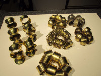 Assorted sets of brass napkin rings and holders.