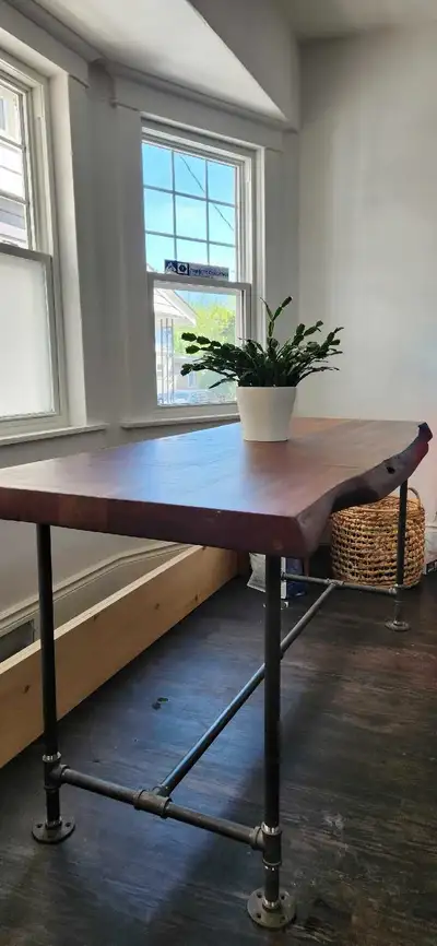 This striking table features a beautiful, one-of-a-kind live edge acacia wood top, showcasing the na...