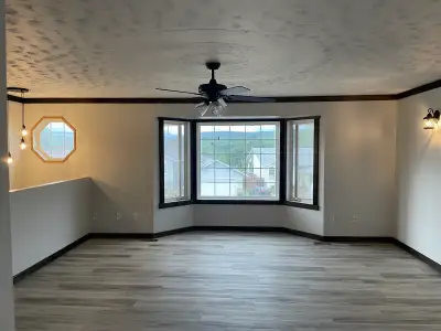 Bright and airy house featuring modern laminate flooring, freshly painted walls, and large bay windo...
