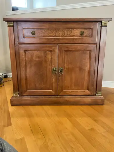 This is a wood china cabinet with a drawer and two doors with shelving inside. It is in good conditi...