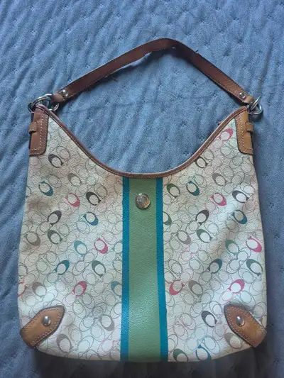 This is a used Coach purse featuring a unique signature design with colourful accents and a brown le...