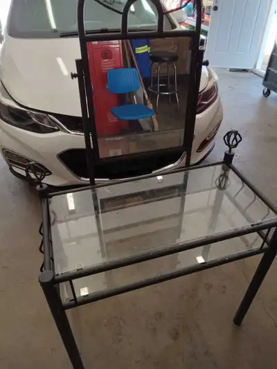 This is a black metal makeup vanity with a glass top, glass is chipped and vanity would have to be c...
