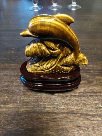 One beautiful piece tigers eye gemstone Hand carved dolphin comes with wood base This is a very uniq...
