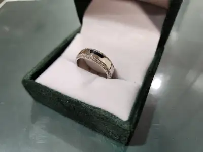 Moissanite set all the way around on both ends of the ring on an angle. Ring is made of sterling sil...
